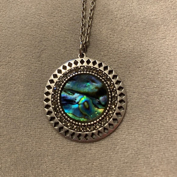 Necklace with blue and silver colored medallion.